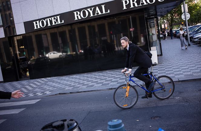 foto muže v obleku jedoucího v Praze na kole