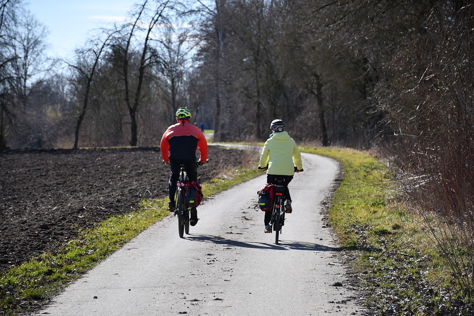 foto dvou jezdců na kole za jízdy