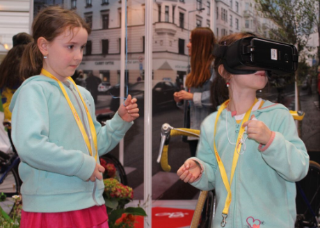 Dvě holčičky v interaktivní části expozice, jedna má 3D brýle