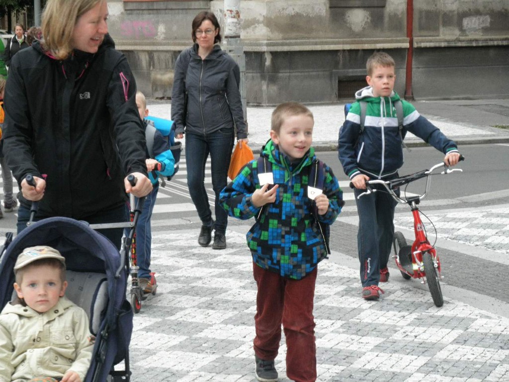 děti před školou, které jdou pěšky a jedou na kole