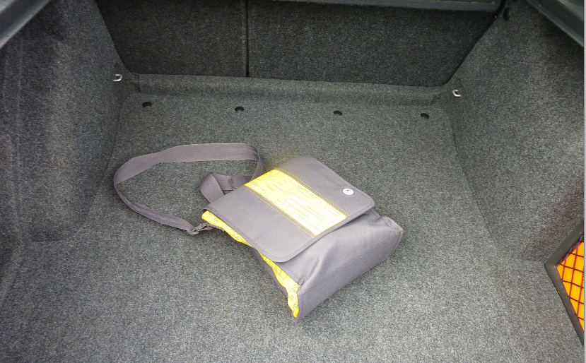 taška přes rameno v kufru auta