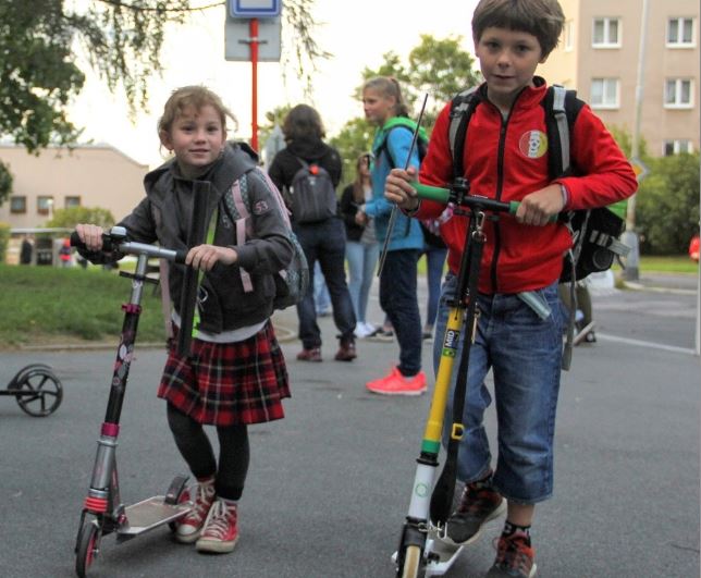 děti s koloběžkami před školou
