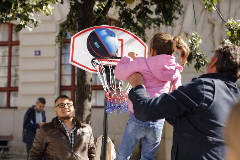 dítě háže basketbalový míč do koše