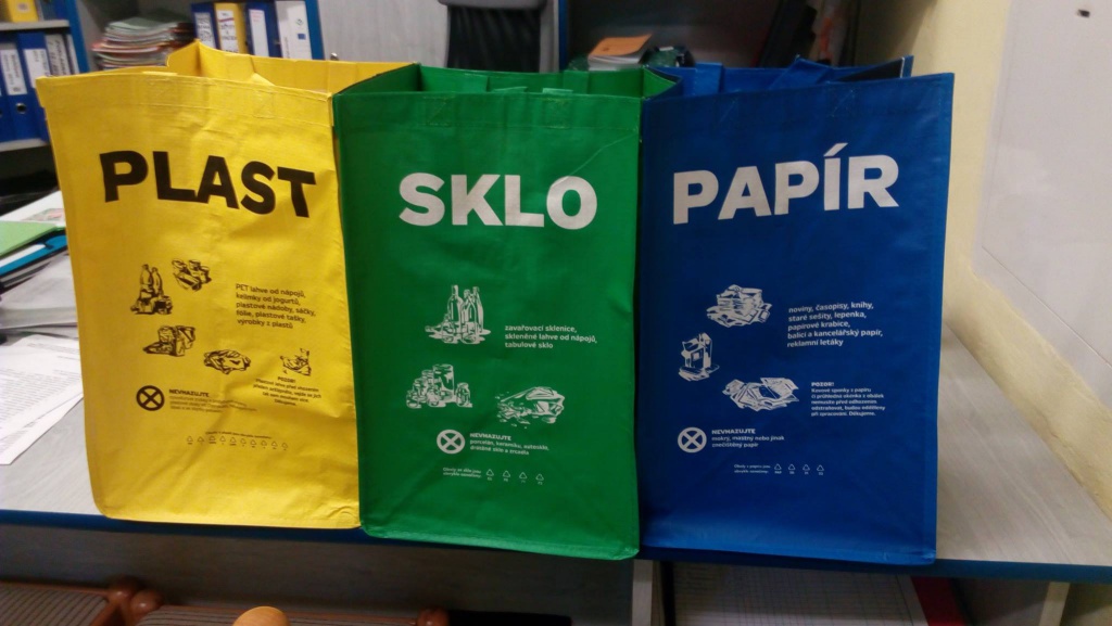 Různobarevné papírové tašky s nápisem sklo, plast, papír