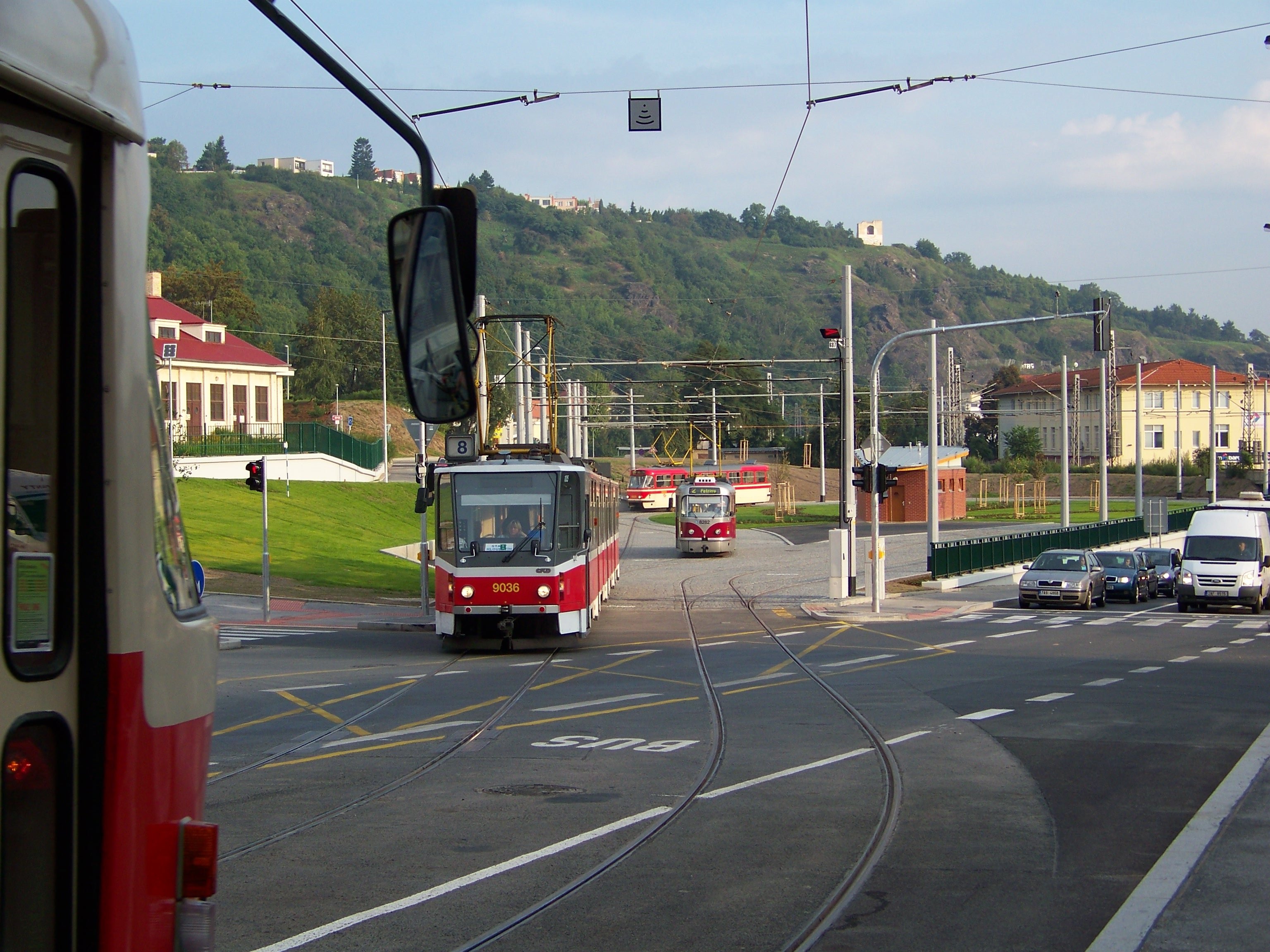 Tramvaj odbočuje, před ní stojí auta