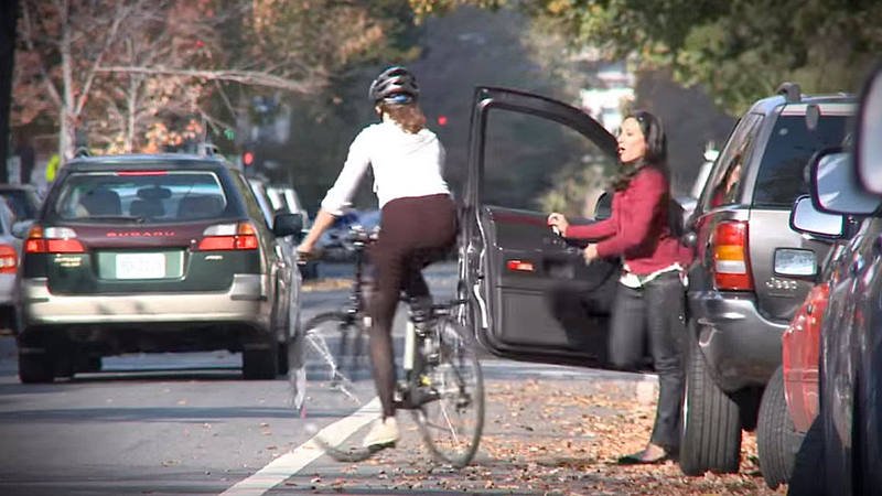 Cyklistka v rychlé reakci objíždí náhle otevřené dveře automobilu