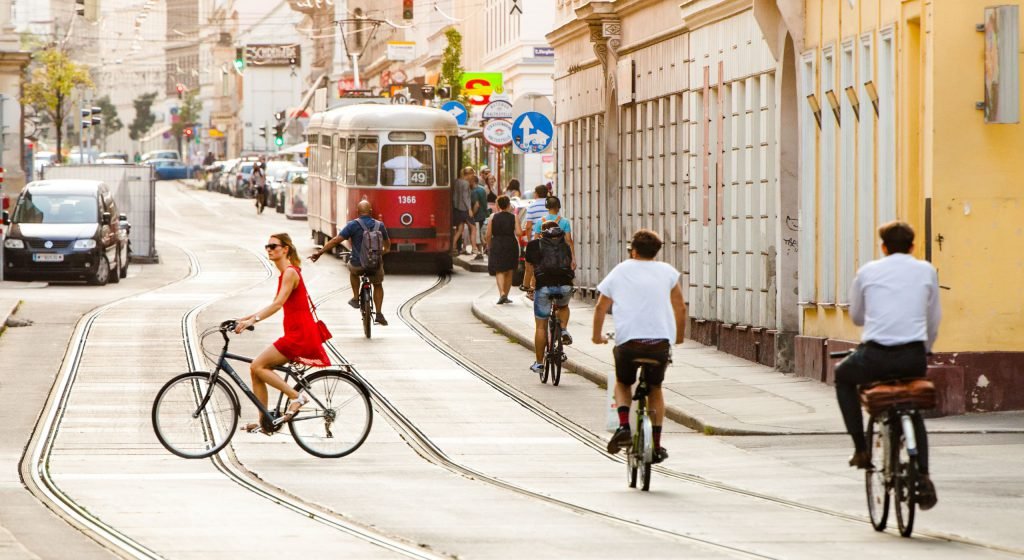Ulice ve Vídni: tramvaj a hodně cyklistů, auta jsou jen zaparkovaná.