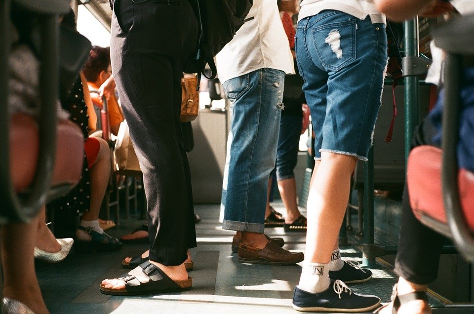 nohy stojících cestujících v tramvaji