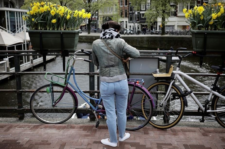 žena stojící v Amsterdamu u bicyklu