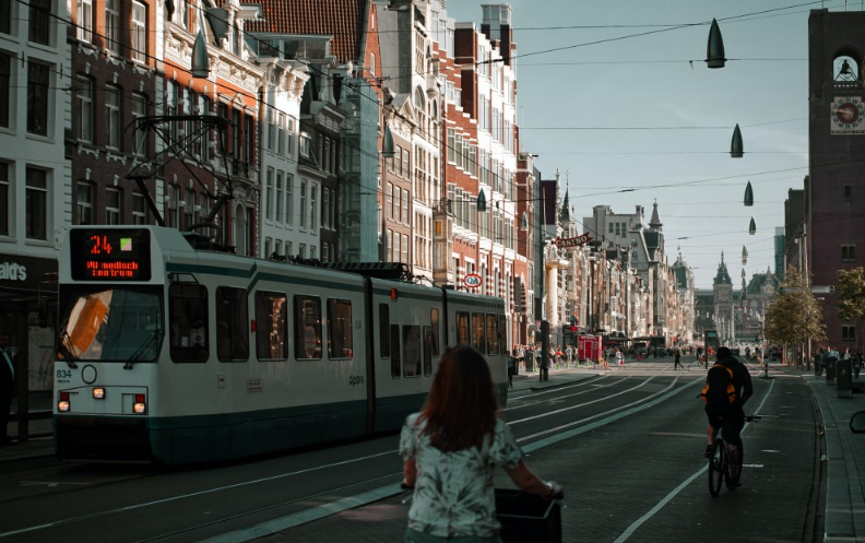 ulice v zahraničí, na ní tramvaj a jízdní kola