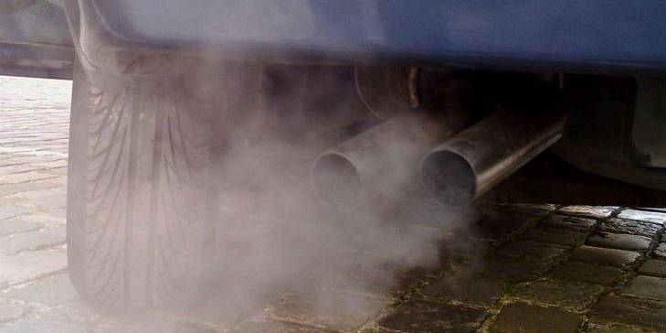stojící auto produkující značné emise z výfuku - foto