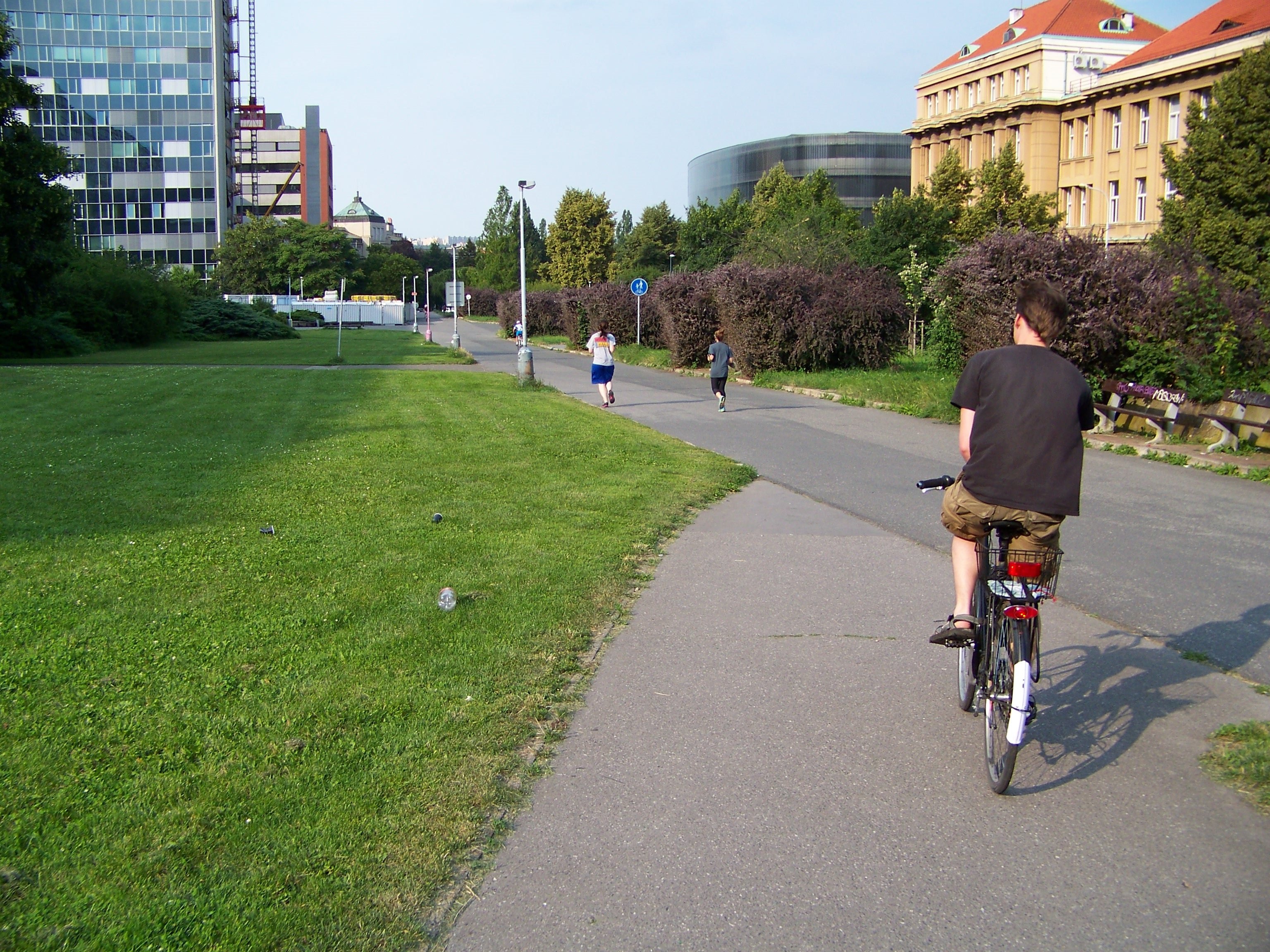 Cyklista jedoucí po cyklostezce, foceno zezadu 