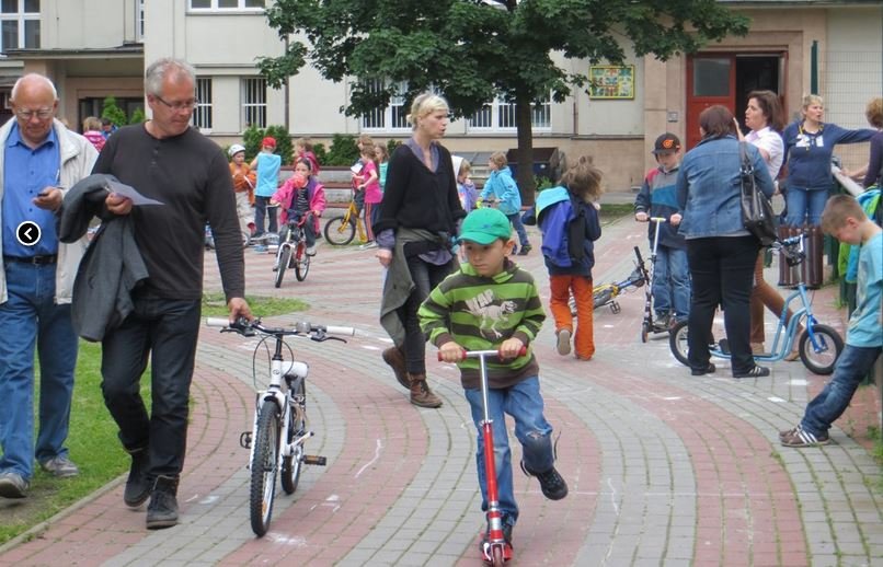 rodiče s dětmi před školou, děti na koloběžce