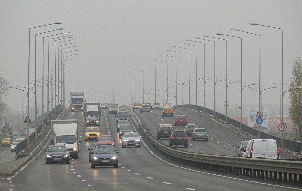 foto: spousta aut na mostě, okolo je smog