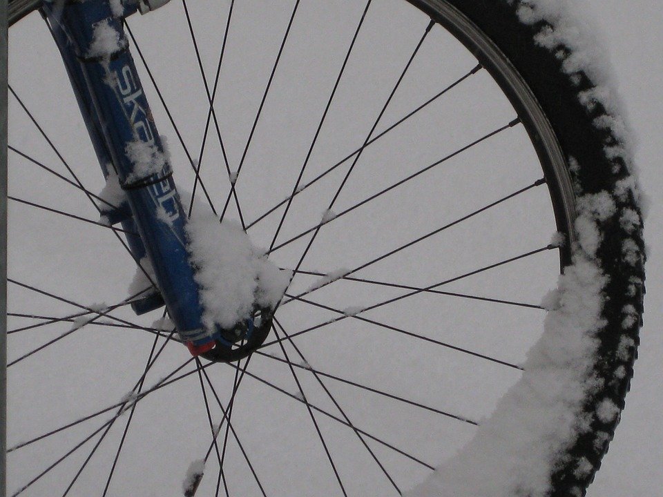 zaparkované kolo, na něm sníh