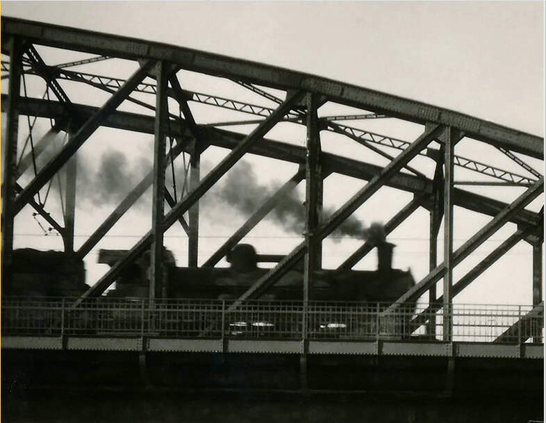 historické foto mostu mezi Výtoní a Smíchovem, jede po něm parní vlak