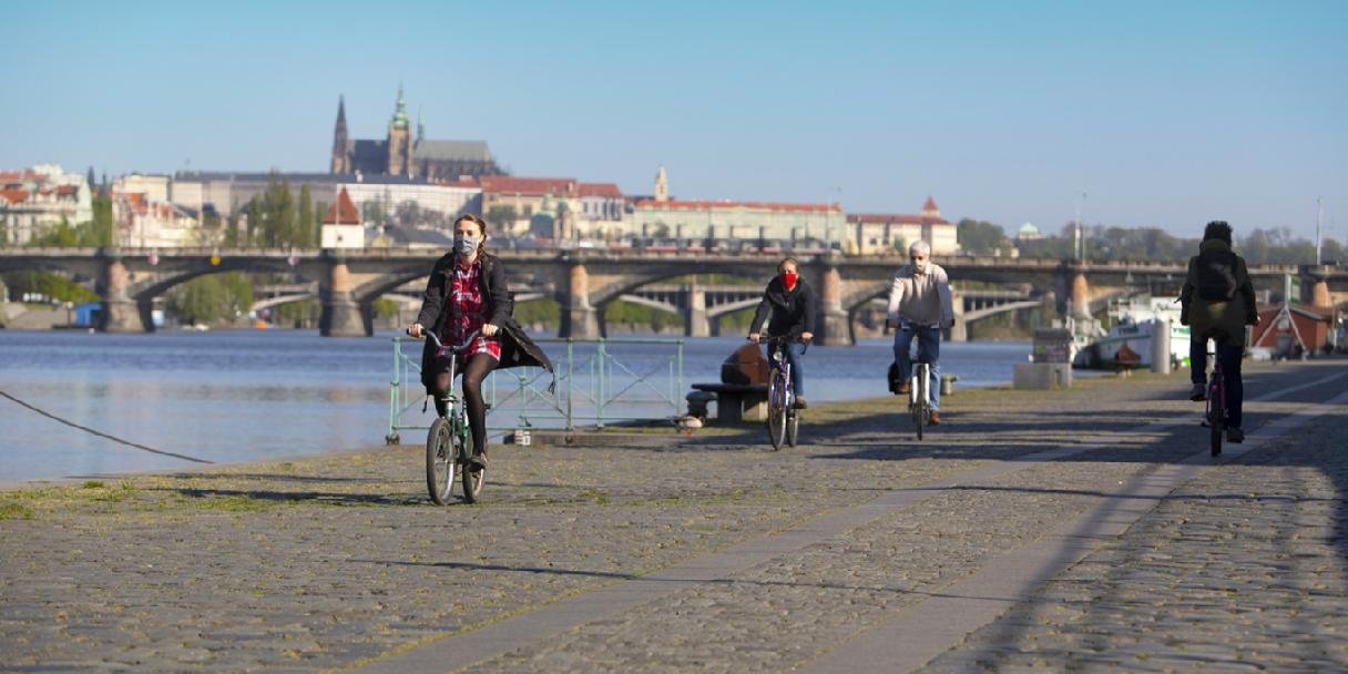 cyklisté v rouškách jedou po pražské Náplavce