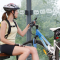 cyklistka přidržující kolo a sedící v železniční zastávce