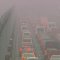 řady automobilů na slinici v hustém smogu