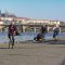 cyklisté v rouškách jedou po pražské Náplavce